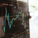 Detailed view of financial trading graphs on a monitor, illustrating stock market trends.